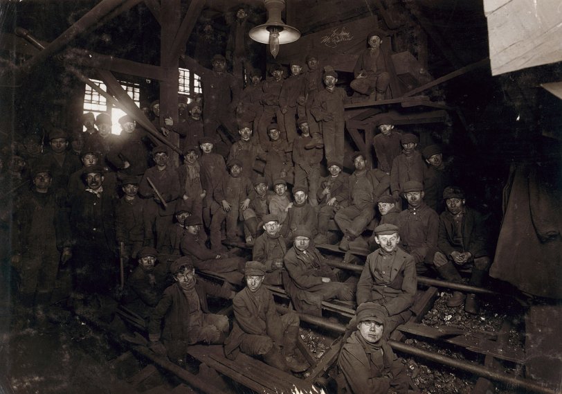 Ewen Breaker: 1911 Noon hour in the Ewen Breaker, Pennsylvania Coal Co., South Pittston. January 1911. Spooky full image. Photograph by Lewis Wickes Hine.
"Breaker boys," or slate pickers, sat astride the breaker chutes, through which the coal roared, and picked out slate and other debris by hand. Boys as young as 8, working ten-hour days, began their coal careers in the breakers. They were paid less than the adults who performed the same work and faced the hazard of hand injuries or even falling into the chutes. Some breaker boys were the sons of miners who had been killed or disabled, often the only remaining source of income for their families. In 1900, boys accounted for one-sixth of the anthracite coal work force. Read a firsthand account of the breaker boys' work.