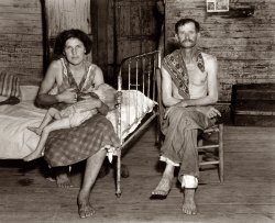 Summer of 1936. William Edward "Bud" Fields, wife Lily Rogers Fields and infant daughter Lilian at their sharecropper cabin in Hale County, Alabama. Photograph by Walker Evans for the Farm Security Administration. View full size.