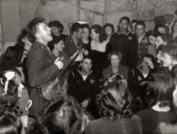 February 1944. The folk singer Pete Seeger entertaining Eleanor Roosevelt, honored guest at a Valentine's Day party to mark the opening of the United Federal Labor Canteen in Washington. View full size. Medium-format safety negative by Joseph Horne for the Office of War Information.