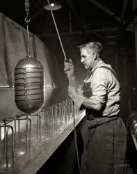 February 1942. Akron, Ohio. "Conversion. Beverage containers to aviation oxygen cylinders. Removal from solution tank at a rubber factory now producing metal essential for the Army. This bath, which follows the removal of the weld scale, gives the inside of the cylinder a further cleaning and removes all chemicals which may remain from the previous operation." 4x5 nitrate negative by Alfred Palmer for the Office of War Information. View full size.