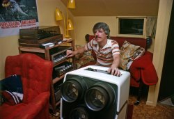 April 1979, still in the early days of the home video revolution, in which I was something of a pioneer. Here I'm at the controls of my Advent VideoBeam projection television, which threw a 5.75-foot wide image onto a silvered screen. I got it in 1976 and my first Betamax VCR the following year - #2 is on the bottom shelf, a 2-hour capable SL-8200, replacing the 1-hour-only SL-7200. The gizmo on the shelf above the Betamax is an Atari Video Music. You ran audio into it, hooked it up to your TV and it produced garish animated abstract electronic patterns bouncing around in response to the musical content, the parameters of which you could control via a bunch of knobs and switches. Devo apparently used one in an early music video.  It was, like, far out man. View full size.

This is in the video room a friend and I built in the basement of my folks' Larkspur house. The window in the back is for the projection of Super-8 films onto the VideoBeam screen via a clever arrangement of front-surfaced mirrors, as that wall is only a foot or so from the huge old gravity furnace. The wide-angle lens distorts the door frame angle.

Just last year I got my third projection video system, the largest yet, and in adjusted dollars it was the cheapest of the three.

Kodachrome (Konica Autoreflex T) via self-timer and bounce flash (Vivitar 273).