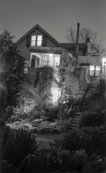 Shorpy being the Historic American Photo Archive, and me being American and at this point in my life historic, I present from my archive a nighttime photo experiment I performed in winter 1962 while a teenage camera geek. This is how I made this time-exposure of our Larkspur, California house: I turned on all the lights in the front-facing rooms, also those on the porches and front walk, and added one more (my desk lamp) below the front porch. I set up the camera (an old c. 1920 folding job) in the cactus garden, opened the shutter, ran down to the bottom of that stairway and wrote out my name with a little flashlight, then ran back up and closed the shutter. Voilà! I used that old camera, a Kodak Folding Autographic Brownie 2A, because it was the only one around the house then that could take time exposures. No tripod receptacle, so I had to balance it on something or other. (I know it's winter because of the burlap sacks covering the lantana for frost protection. Oh, and before you ask, no, we're not related to the Addams family.) Scanned from the original "116" 2½ x 4¼ negative, slightly cropped at top. View full size.