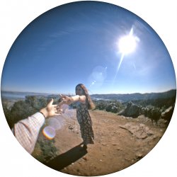 High atop Christmas Tree Hill above Corte Madera, California, I reach out from my fisheye lens to my sister-in-law. Sort of like Michelangelo meets Coca-Cola commercial. In the near distance, southern Marin County's Richardson Bay, Sausalito and the Tiburon peninsula, with San Francisco Bay and the City beyond. The antennas a bit down the crest of the hill are for the Marin cable TV system. The "Christmas Tree Hill" moniker came about because decorated houses on the slope formed something of a Christmas tree pattern when viewed from a distance. Kodachrome slide. Update/correction: my brother took this shot, and it's his arm; I'm actually partly visible back there with my tripod and movie camera.  View full size.