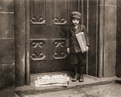 "Newsboy, 1913. No caption card found. Date based on captions for neighboring numbers. 'Pittsburg' may be in text at top of newspaper on ground, but neighboring newsboy photos taken in New York. Headline appears to be 'Judges Avert Probe and Save Blakeley'." Photo by Lewis Wickes Hine for the National Child Labor Committee. View full size.