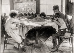 February 1910. "10 a.m. Saturday. 36 Laight Street, New York. Florence Lieto, 10 years old; Jennie Macola, 10 years old (hidden); Mamie Macola, 8; Nicholas Macola, 6. Picking coffee sweepings. The sweepings cost 25 cents a sack at the warehouse, and picked-over coffee sells at about 12 cents a pound. Man working with sore hand tied up in bandage. Children work after school hours and on Saturdays." Photo by Lewis Wickes Hine. View full size.