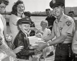 &nbsp; &nbsp; UPDATE: It's October 2, 1960, and the boy is "doomed youngster" Rickey Stowell.
In a sequel to this photo, we're back in Richmond, California, circa 1960. Several 3-packs of "100% Combed Cotton Boys' Briefs" are being handed over. There must be a story here, but we don't know what it is. 4x5 acetate negative from the News Photo Archive. View full size.