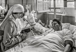 September 1918. "Base Hospital 41, Saint-Denis, France. 'I'm Joe from Missouri. Please tell my girl I'm all right.' The Red Cross Lady lends a hand -- Red Cross nurse writes a letter for an American soldier whose right arm is disabled." 5x7 inch glass negative by Lewis Wickes Hine for the American National Red Cross. View full size.