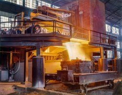 1942. "White-hot steel pours like water from a 35-ton electric furnace at Allegheny Ludlum Steel Corp., Brackenridge, Pa. The finest quality steels and alloys are produced in these furnaces, which allow much greater control of temperature than other conversion furnaces. The proportion of electric furnace steel is rising steadily, even though this process is the most expensive. The furnace is tilted for the pouring; the flying sparks indicate the fluidity of the steel." 4x5 Kodachrome transparency by Alfred Palmer for the Office of War Information. View full size.