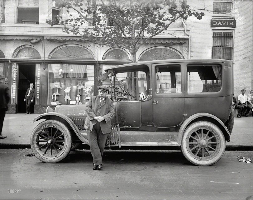 &nbsp; &nbsp; &nbsp; &nbsp; Using the Internets and clues provided by the photo, you should be able to figure out who this is! It took me about 15 minutes. (SPOILER: The mustachioed gent is most likely W.V. Wolfe, proprietor of the Frederick & Washington Bus Line, advertised in the sign behind the car -- which was actually the bus.) 
Washington, D.C., 1921. "Studebaker car." Surrounded by a number of colorful-looking characters. 8x6 glass negative, National Photo Co. View full size.