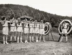&nbsp; &nbsp; &nbsp; &nbsp; "Girl archers from Camp Greystone, Tuxedo, N.C., demonstrate fancy shooting attired in latest fashion for the bow and arrow sport -- 'shorts' and sox."
August 23, 1928. "A perfect miss with every shot -- Miss Isabel Bonsack of St. Louis, Mo., has a right to feel happy that her fellow members of the Camp Greystone archery team are skillful markswomen. Miss Bonsack volunteered to act as a target during an exhibition of girl archers at the Grove Park Inn, Asheville, North Carolina." Gelatin silver print. View full size.