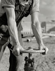 June 1942. "Tennessee Valley Authority power and conservation. Fort Loudoun Dam construction. Workman opening valve on a new pipeline of Fort Loudoun Dam, farthest upstream of the TVA's main Tennessee River projects. Scheduled for closure and first storage of water early in 1943, this dam will create a 15,000-acre lake reaching 55 miles upstream to the city of Knoxville. The reservoir will have a useful storage capacity of 126,000 acre-feet. Power installation of 64,000 kilowatts is authorized, with a possible ultimate of 96,000 kilowatts." Medium format negative by Alfred Palmer for the Office of War Information. View full size.