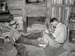 July 1939. "Resident of May Avenue camp, Oklahoma City, taking piece of glass out of boy's foot." Medium format negative by Russell Lee. View full size.