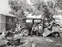 November 1936. "Migratory family in automobile camp, California." Photo by Dorothea Lange for the Farm Security Administration. View full size.