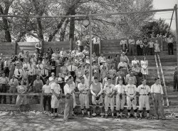 July 1941. Vale, Oregon. "Baseball players and spectators stand at attention while Chief Justice Stone gives the oath of allegiance over the radio." Medium format negative by Russell Lee for the Farm Security Administration. View full size.