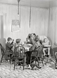 October 1940. "Mr. Lawrence J. Brown, Aroostook potato farmer, operates a small seed foundation unit in Eagle Lake, Maine. His three sons and one hired man do all the work. The little boy on the left picked fourteen barrels of potatoes before lunch." Medium format acetate negative by Jack Delano for the Farm Security Administration. View full size.