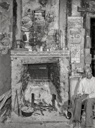 June 1940. "Melrose, Natchitoches Parish, Louisiana. Fireplace in old mud hut built and still lived in by French mulattoes near John Henry cotton plantation. 'Uncle' Joe Rocque, about 86 years old." Photo by Marion Post Wolcott for the Farm Security Administration. View full size.