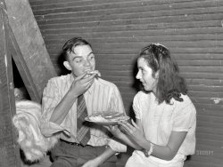 September 1940. "Quicksand School, Breathitt County, Kentucky. Many parents and young people from the school and nearby communities attend the pie and box supper, given by the school to raise money for repairs and supplies. Each box or pie is auctioned off to the highest bidder, sometimes bringing a good deal, since the girl's 'boyfriend' usually wins and has the privilege of eating it with her afterwards." Medium format acetate negative by Marion Post Wolcott for the Farm Security Administration. View full size.