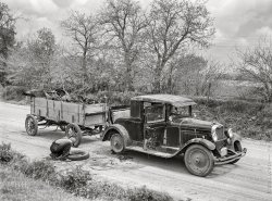 May 1942. "Kearney, Buffalo County, Nebraska. Farm boy with flat tire, which happened while he was bringing a load of scrap iron to town." (Does that include the car?) Medium format acetate negative by John Vachon for the Farm Security Administration. View full size.