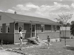 June 1942. "Sheffield, Alabama (Tennessee Valley Authority). Housing for defense workers. Kenneth Hall gives daughter Peggy a shower with garden hose in front of their TVA defense home." The nice people last seen here. Acetate negative by Arthur Rothstein. View full size.