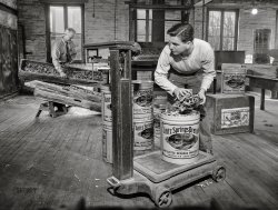 November 1942. Lititz, Pennsylvania. "Lititz Springs Pretzel Company, owned by Lewis C. Haines (background), who is unloading a tray of pretzels which has come up on a dumbwaiter from the baking room below. A son, Bob, weighs them and packs them in cans. Lititz was the first town in America where pretzels were made." Photo by Marjory Collins. View full size.
