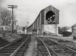 November 1942. Lititz, Pennsylvania. "Tracks of the Lancaster-Reading Railroad. Two trains come through every day. In the distance is the local chocolate factory." Acetate negative by Marjory Collins for the Office of War Information. View full size.