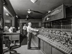 February 1943. "Chicago, Illinois. In the interlocking tower at Union Station. It is here that all inbound and outbound traffic is controlled. The men work entirely by the board, hardly ever looking out of a window to see an actual train." Acetate negative by Jack Delano for the Office of War Information. View full size.