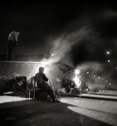 May 1943. "Bethlehem-Fairfield shipyards, Baltimore, Maryland. Liberty ship construction. Welding on a hatch assembly at night." Medium format negative by Arthur Siegel for the Office of War Information. View full size.