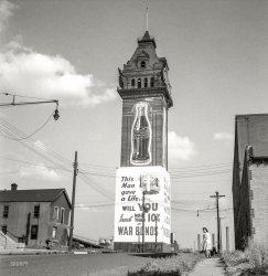&nbsp; &nbsp; &nbsp; &nbsp; UPDATE: Our astute commenters wasted no time in locating the photo in Minneapolis; Shorpy member "billymaz" identified the structure as a remnant of the 1886 Minneapolis Industrial Exposition Building. The building's final owner, the Coca-Cola Company, tore it down in 1940 to make room for a new bottling plant, leaving just the northwest tower, which stood for a few more years as a vestige of what was once one of the most prominent buildings in the city. (MNopedia)
This uncaptioned circa 1943 photo taken for the Office of War Information shows a brick tower, probably in the Upper Midwest, repurposed as advertising for War Bonds and Coca-Cola. Who'll be the first to tell us where this is? View full size.