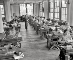 June 1937. "Baltimore, Maryland. For every Social Security account number issued an 'employee master card' is made in the Social Security board records office. Testifying data, given on the application blank form SS-5, is transferred to this master card in the form of upended quadrangular holes, punched by key punch machines, which have a keyboard like a typewriter. Each key struck by an operator causes a hole to be punched in the card. The position of a hole determines the letter or number other machines will reproduce from the master card. From this master card is made an actuarial card, to be used later for statistical purposes. The master card also is used in other machines which sort them numerically, according to account numbers, alphabetically according to the name code, translate the holes into numbers and letters, and print the data on individual ledger sheets, indexes, registry of accounts and other uses. The photograph above shows records office workers punching master cards on key punch machines." Whew. Longest caption ever? Harris & Ewing Collection glass negative. View full size.