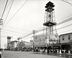 New York circa 1904. "Surf Avenue, Coney Island." Points of interest: The "Great Musical & Scenic Railway" roller coaster ("Day & Night in the Alps"), an observation tower advertising Steeplechase Park and, at left, the "Mont Pelee" and "Galveston Flood" cycloramas commemorating the catastrophic volcanic eruption and hurricane. Bonus attraction: much Moxie signage. View full size.