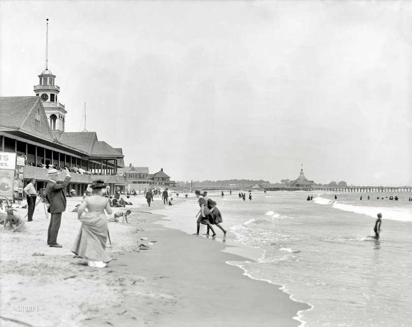 Narragansett Pier: 1910 Rhode Island circa 1910. "Narragansett Pier bathing beach." Note the photographer and signage to the left: "Want a Picture Taken in Your BATHING SUIT? 4 for 50 cents -- All Work Done by the LIGHTNING PROCESS." 8x10 inch dry plate glass negative, Detroit Publishing Company. View full size.
