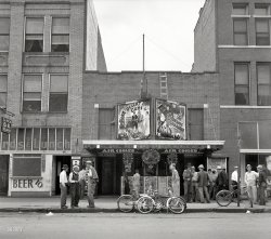 June 1937. "Oklahoma City. Idle men attend the morning movies. There are three such movies in one block." Now playing: Desert Guns and The Singing Vagabond. Photo by Dorothea Lange, Farm Security Administration. View full size.