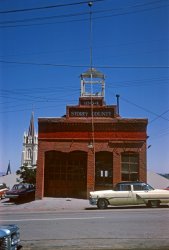 I thought about titling this "A Study in Kodachrome Blue and Red" but didn't. I took it on a trip to the historic Nevada silver mining town in August 1965. The building now houses the Comstock Fire Museum, and the steeples are St. Paul's Episcopal and St. Mary in the Mountains. I was going to identify the cars by make and year, but why should I spoil all the fun? View full size.